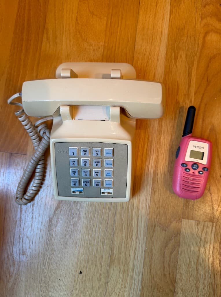 Old landline phone next to kids’ walkie-talkies