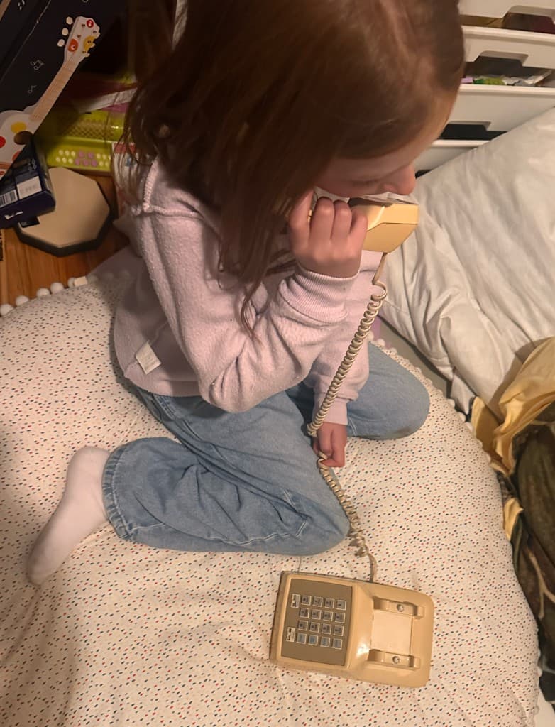 Girl pretending to call on an old landline phone